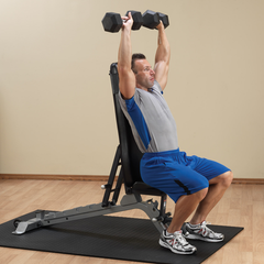 Man using a Flat Incline Bench to perform an overhead dumbbell press for strength training.