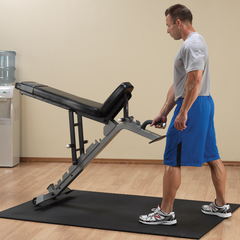 Man adjusting a Flat, Incline Bench in a gym setting, showcasing the Body-Solid SFID325 Commercial Adjustable bench.